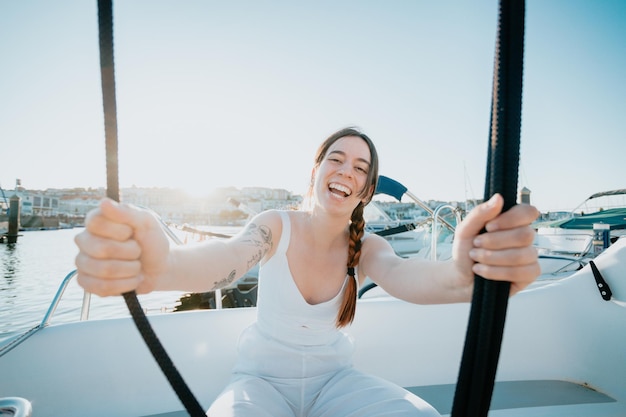 Młoda kobieta ciesząca się letnimi wakacjami przy swoim jachcieluksusowy rejs jachtem podróż po morzu luksusową łodziąMłoda szczęśliwa kobieta na pokładzie łodzi żegluje po morzu Jachting w GrecjiHiszpania czas zachodu słońca
