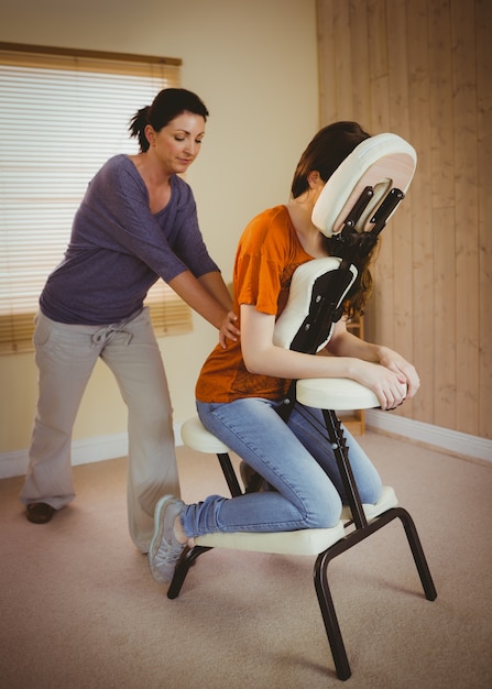 Zdjęcie młoda kobieta coraz masaż w fotelu