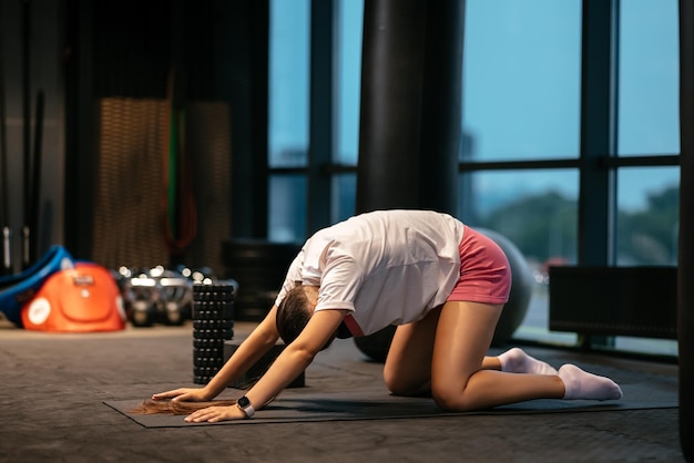 Młoda kobieta ćwiczy robienie ćwiczeń jogi lub pilates