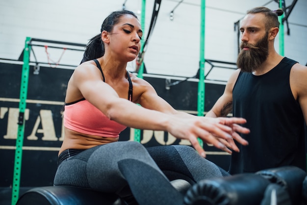 Młoda kobieta ćwiczy salową gym z osobistym trenerem