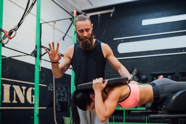 Młoda kobieta ćwiczy salową gym z osobistym trenerem