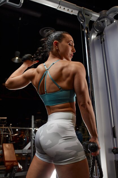 Zdjęcie młoda kobieta ćwiczy w siłowni.