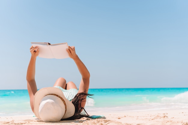 Młoda Kobieta, Czytanie Książki Na Szezlong Na Plaży