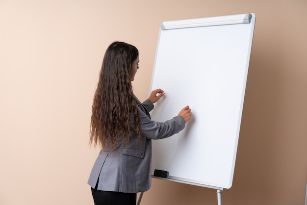 Zdjęcie młoda kobieta daje prezentaci na białej desce daje prezentaci na białej desce i pisze w nim