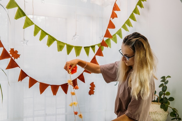 Młoda kobieta dekoruje dom na halloween wnętrze domu udekorowane na halloween z diy