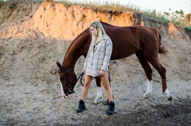 Młoda kobieta dziewczyna pasąca konia na tle natury, miłość i troska o zwierzęta natur