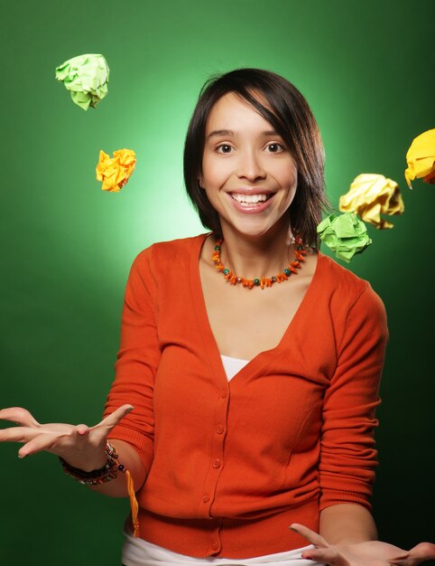 Młoda kobieta ekspresyjna z papierowym ptakiem na zielonej ścianie