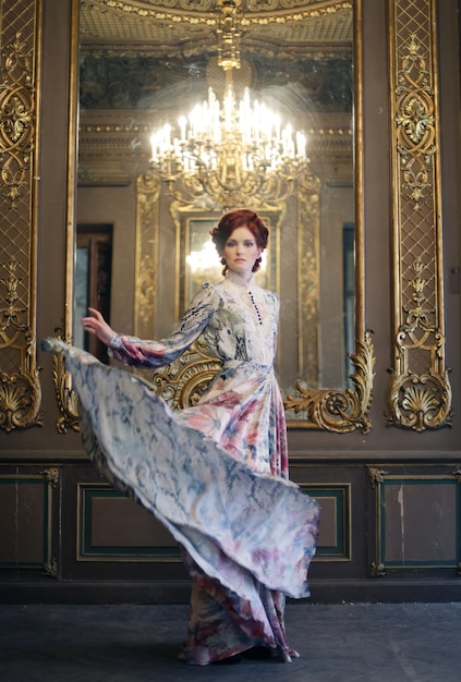 Młoda kobieta elegancja z latania sukienka w pokoju pałacu