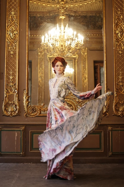 Młoda kobieta elegancja z latania sukienka w pokoju pałacu