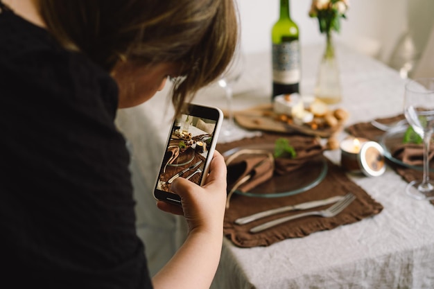 Młoda kobieta filmuje aparatem w telefonie produkty kuchenne do swojego sklepu internetowego Prowadzenie wideobloga Vlogger prowadzi transmisje online za pomocą telefonu Sieci społecznościowe zostań w domu i poddaj się kwarantannie