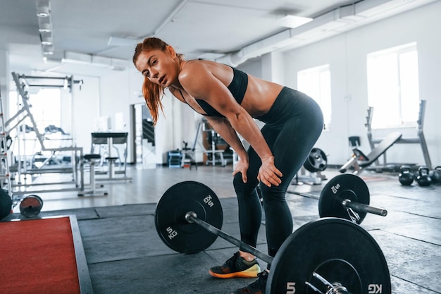 Młoda Kobieta Fitness O Szczupłej Sylwetce, Wykonująca ćwiczenia Przy Użyciu Sztangi