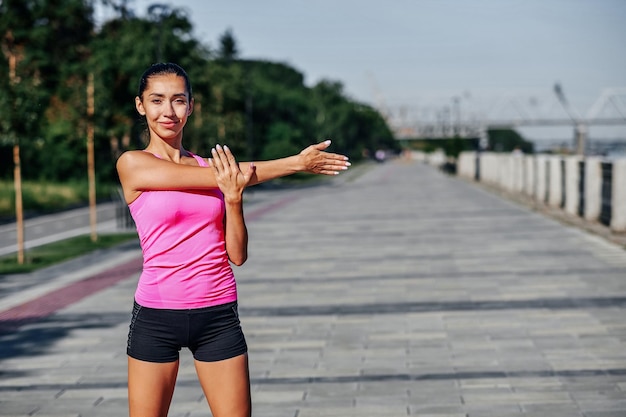 Młoda kobieta fitness rozciąganie rąk po biegu na świeżym powietrzu po biegu