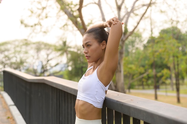 Młoda kobieta fitness w stroju sportowym ćwicząca w parku miejskim Zdrowy i styl życia