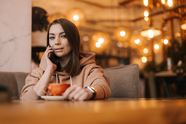 Młoda kobieta freelancer w zwykłych ubraniach rozmawia przez telefon