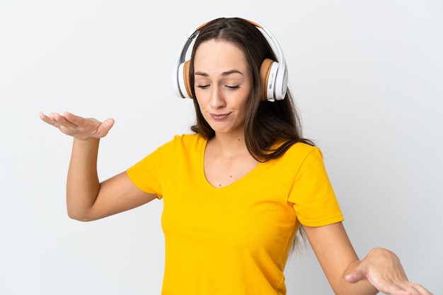 Młoda kobieta hiszpanin na pojedyncze białe ściany słuchania muzyki i tańca