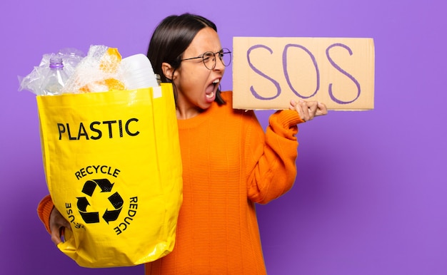 Młoda kobieta hiszpanin z tablicą SOS i plastikiem do recyklingu