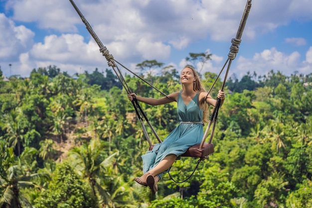 Młoda kobieta huśta się w dżungli na wyspie Bali Indonezja Huśtawka w tropikach Trend huśtawek na Bali