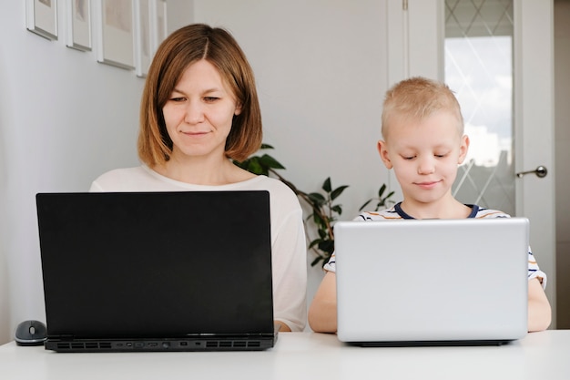 Zdjęcie młoda kobieta i jej synek za pomocą laptopów