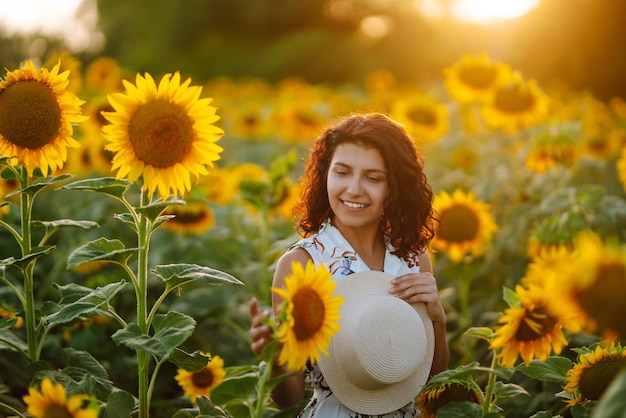 Młoda kobieta idzie na kwitnące pole słonecznika Szczęście z naturą Wakacje letnie