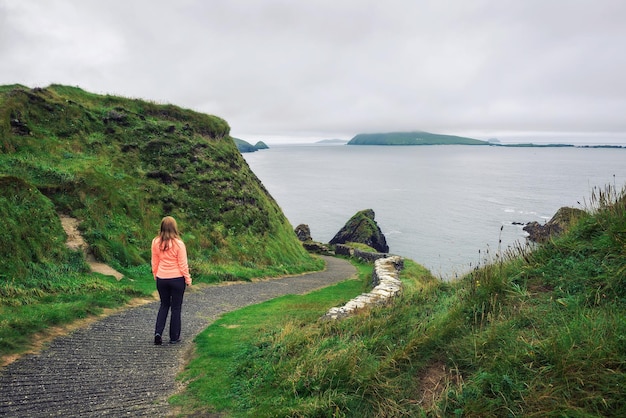 Młoda kobieta idzie ścieżką otoczoną irlandzkim krajobrazem
