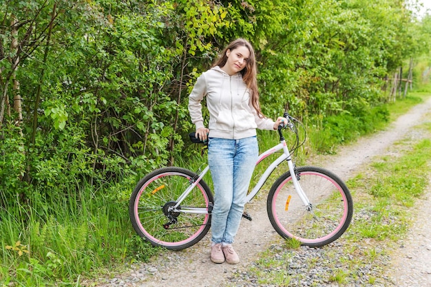 Młoda kobieta jedzie na rowerze w letnim parku miejskim na świeżym powietrzu Aktywni ludzie Hipster dziewczyna zrelaksować się i jeździec na rowerze