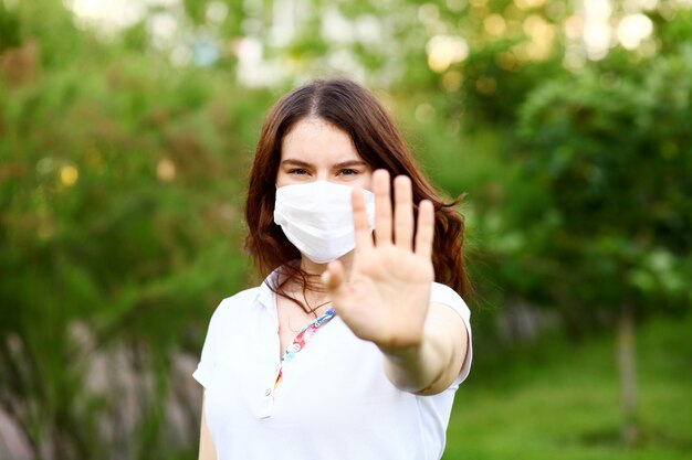 Zdjęcie młoda kobieta jest ubranym ochronną maskę w naturze