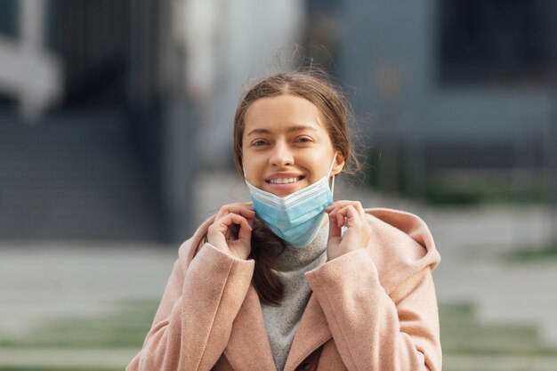 Młoda kobieta jest ubranym ochronną twarzy maskę outdoors