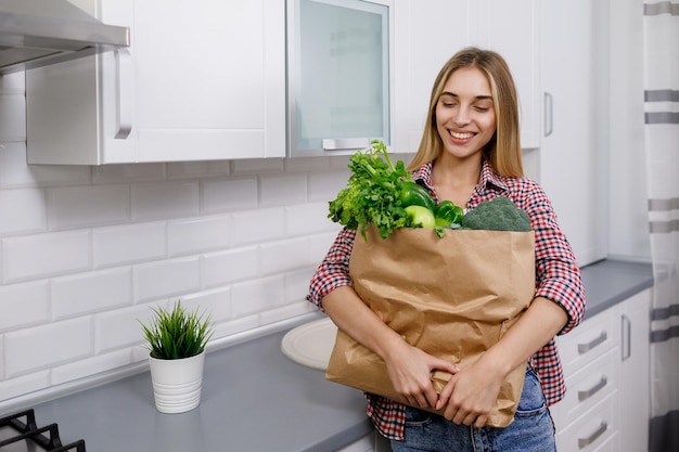 Młoda kobieta jest zadowolona z zakupów w warzywniaku