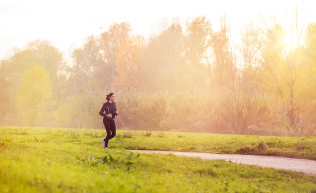 Młoda Kobieta Joggingu W Parku O Zachodzie Słońca