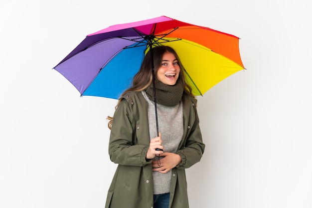 Młoda kobieta kaukaska trzyma parasol na białym tle uśmiecha się dużo
