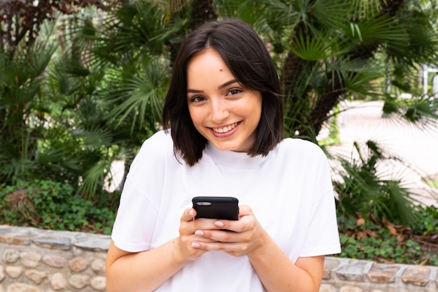 Młoda kobieta kaukaski przy użyciu telefonu na zewnątrz