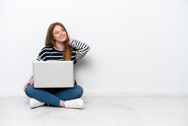 Młoda kobieta kaukaski z laptopa siedząc na podłodze