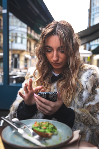 Zdjęcie młoda kobieta kaukaski za pomocą telefonu komórkowego