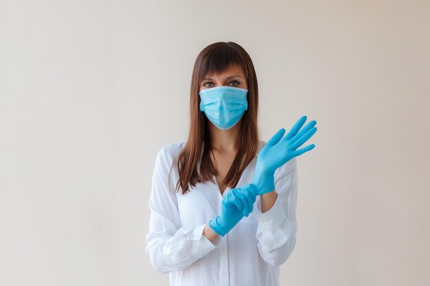 Młoda kobieta kaukazyjska nosząca maskę oddechową i używająca rękawiczek ochronnych w celu zapobiegania zakażeniom Koncepcja medyczna ochrony przed wybuchem wirusa Covid-19 przeziębienia choroby układu oddechowego