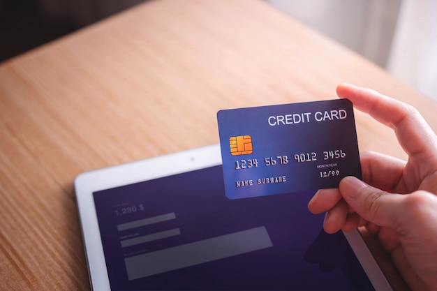 Młoda kobieta klient używa kredytową kartę i pastylkę Zapłata Online