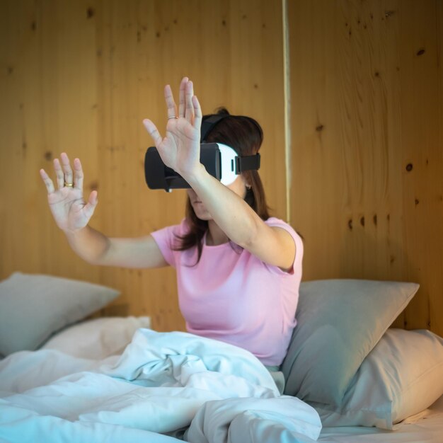 Młoda Kobieta Korzystająca Z Zestawu Słuchawkowego Wirtualnej Rzeczywistości W łóżku Vr Przyszła Technologia Cyfrowa Gry Filmy Rozrywka Metaverse Nft I Koncepcja Cyberprzestrzeni 3d
