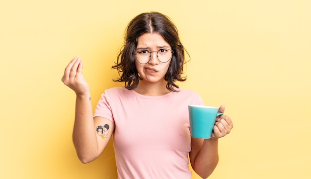 Zdjęcie młoda kobieta latynoska co capice lub pieniądze gest, mówiąc, aby zapłacić. koncepcja kubek kawy
