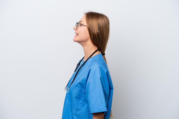 Młoda kobieta lekarz pielęgniarka na białym tle śmiejąca się w pozycji bocznej