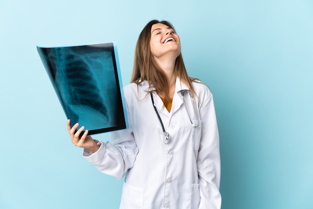 Młoda kobieta lekarz trzymając radiografii na białym tle śmiejąc się