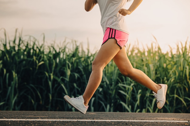 Młoda kobieta lekkoatletka biegacza na drodze do zdrowia, młodzi ludzie biegający ćwiczenia na ulicy
