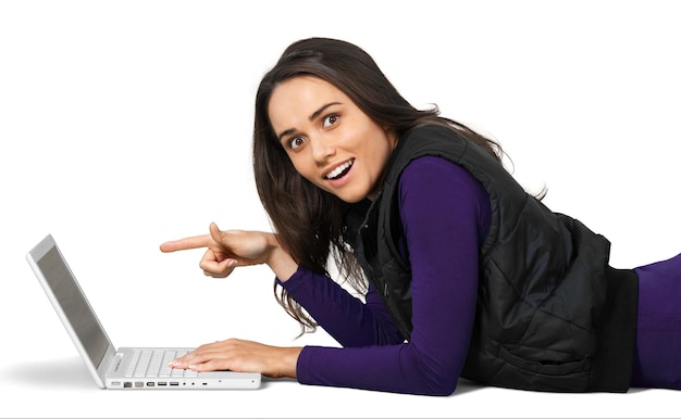 Młoda kobieta leżąca przed laptopem