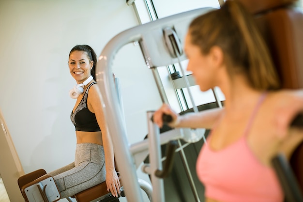 Młoda kobieta ma szkolenie przy porywacz maszyną w gym