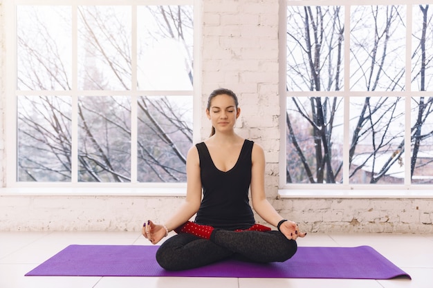 Młoda kobieta medytuje samotnie w domu, wolność pokojowej spokojnej dziewczyny ćwiczy joga w lotos pozie