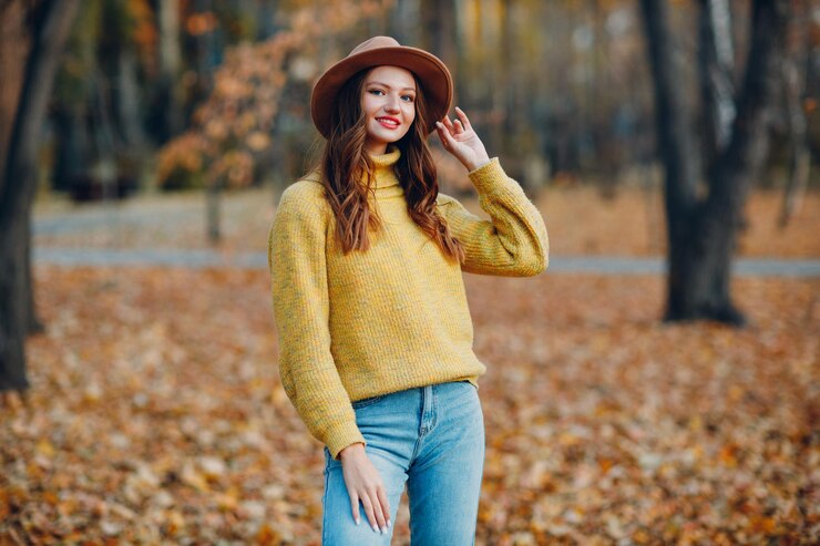 Zdjęcie młoda kobieta modelka w jesiennym parku z żółtymi liśćmi klonu jesienna moda