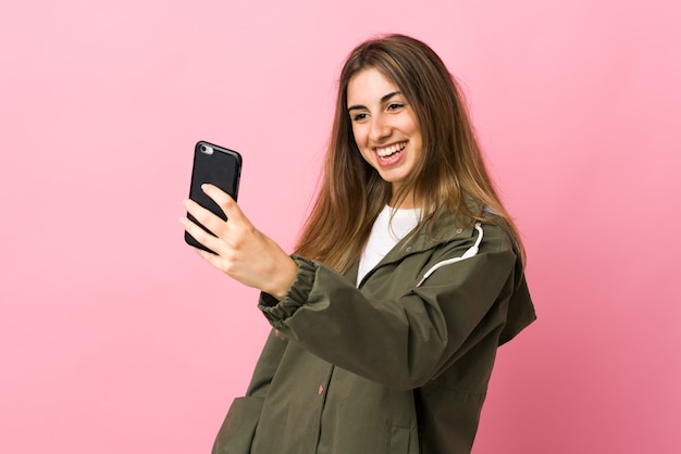 Młoda kobieta na na białym tle różowy Dokonywanie selfie