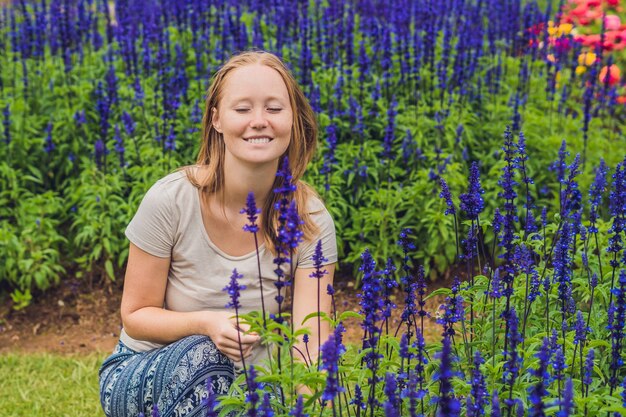 Młoda Kobieta Na Powierzchni Kwitnących W Ogrodzie Kwiatów Blue Salvia Farinacea