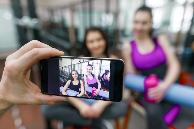 Zdjęcie młoda kobieta na siłowni, sfotografowany na telefon komórkowy