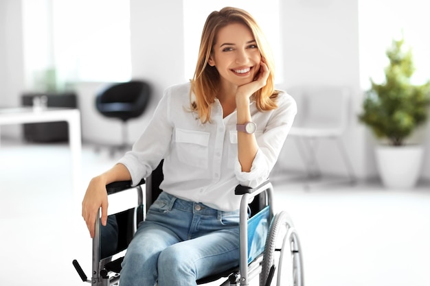 Młoda kobieta na wózku inwalidzkim w miejscu pracy