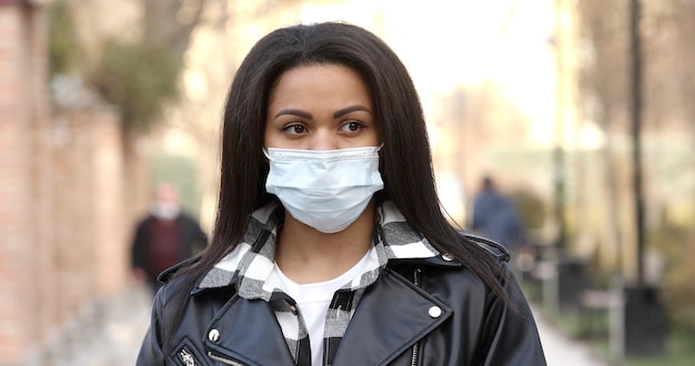 Młoda Kobieta Nosi Maskę Ochronną W Mieście. Zamaskowany Afro-amerykańska Dziewczyna Na Ulicy Miasta.
