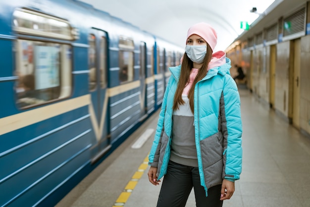 Młoda Kobieta O Kaukaskim Wyglądzie W Ciepłych Ubraniach W Metrze W Masce Ochronnej Przed W...